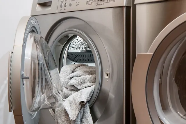 Front-load washing machine with the door open and towels inside