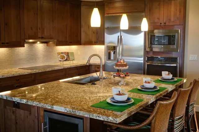 Kitchen with a stainless French-door refrigerator, built-in microwave and wall oven, glass cooktop and under-counter wine cooler