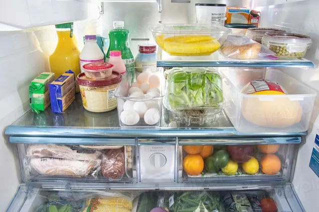 Refrigerator interior with stocked glass shelves and crisper drawers